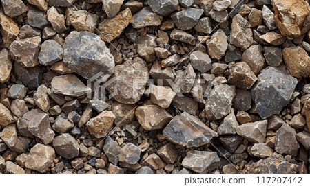 Rocks stacked on the ground, maybe for building or a stone wall 117207442