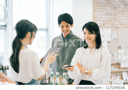 一對夫婦在咖啡館用智慧型手機付款 117209108