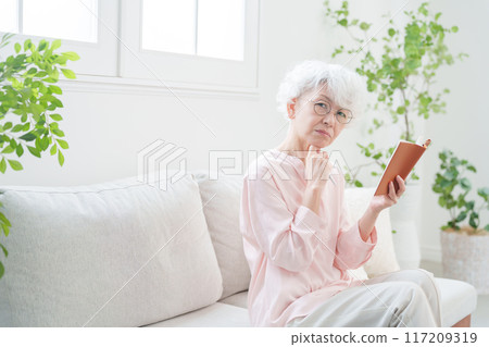 在筆記本上做筆記的高級女性 117209319