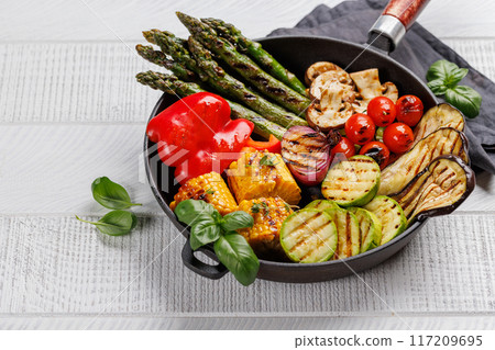 Assorted grilled vegetables on a frying pan, showcasing a colorful meal Assorted grilled vegetables on a frying pan, showcasing a colorful meal 117209695