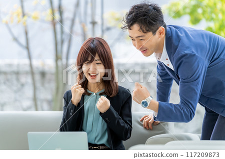 日本男女商人一邊看電腦一邊握拳很高興 117209873