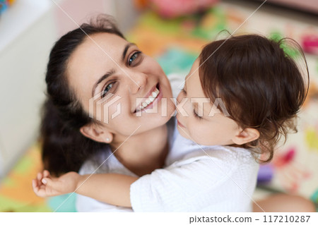 happy mother with cute baby girl in white t-shirt having fun together happy mother with cute baby girl in white t-shirt having fun together 117210287
