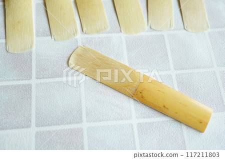 A worn and chipped clarinet reed 117211803