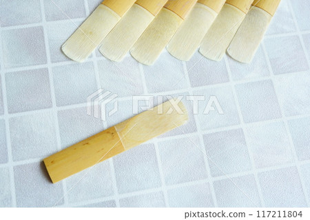 A worn and chipped clarinet reed 117211804