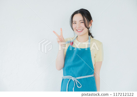 A woman in an apron looking at her smartphone A woman in an apron looking at her smartphone 117212122