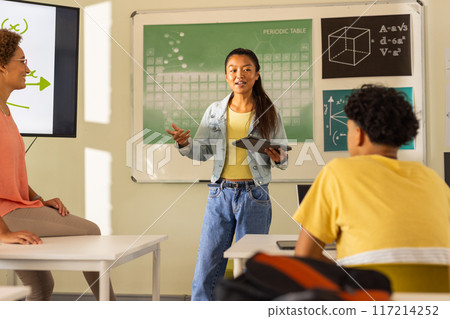 Presenting project in high school, teenage girl holding tablet with classmates watching 117214252