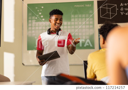 Presenting project, teenage boy with tablet smiling in high school classroom 117214257
