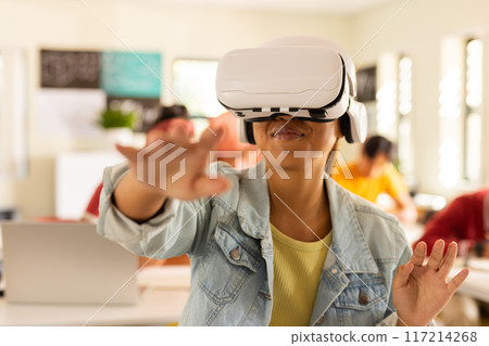 Using VR headset, teenager exploring virtual reality in high school classroom Using VR headset, teenager exploring virtual reality in high school classroom 117214268