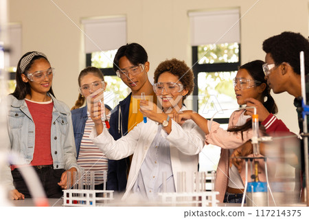 Conducting science experiment with test tubes, students in high school laboratory 117214375