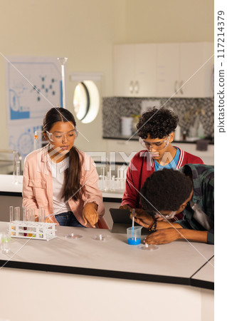 Conducting science experiment with test tubes and tablet, students in high school laboratory Conducting science experiment with test tubes and tablet, students in high school laboratory 117214379