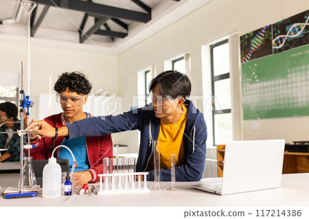 In high school, teenagers conducting science experiment with lab equipment and laptop In high school, teenagers conducting science experiment with lab equipment and laptop 117214386