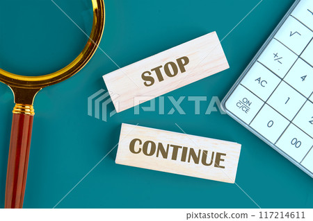 Conceptual symbol. Copy space. Stop or continue words written The inscription is made up of wooden toy blocks Conceptual symbol. Copy space. Stop or continue words written The inscription is made up of wooden toy blocks 117214611