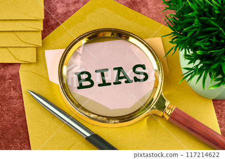 Business concept. The word Bias written through a magnifying glass in a letter peeking out of an envelope 117214622