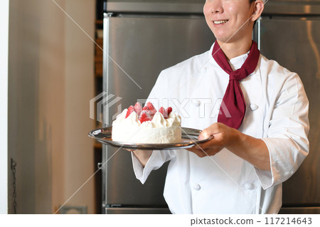 Asian male pastry chef holding a cake Asian male pastry chef holding a cake 117214643