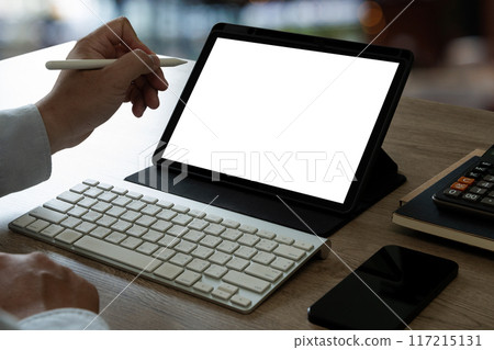 A businessman holds a mockup. iPad digital tablet with blank screen Mockup replaces your design mockup in the office. A businessman holds a mockup. iPad digital tablet with blank screen Mockup replaces your design mockup in the office. 117215131