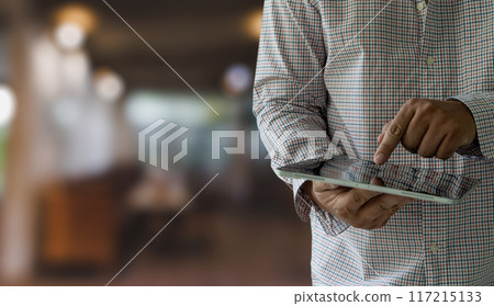 businessman holds a mockup. iPad digital tablet in office multitasking searching the internet 117215133
