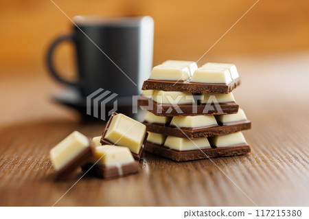 White light dark chocolate bars on wooden table. 117215380