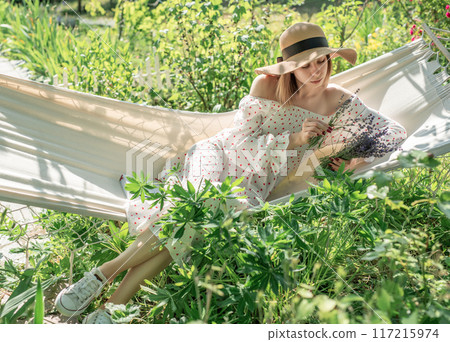 Young woman relaxing in a hammock outdoors 117215974