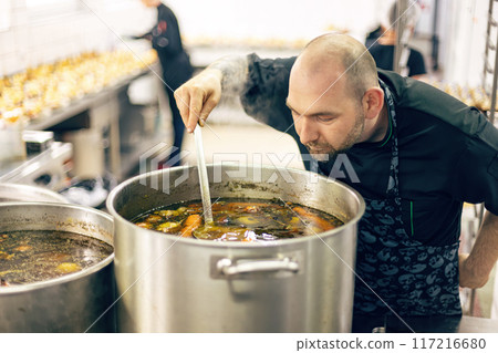 Professional chef carefully tasting 117216680