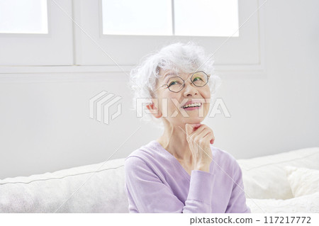Senior woman imagining in living room 117217772