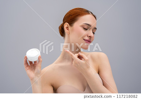 Pretty young woman trying a new face cream and looking relaxed and enjoyed 117218082