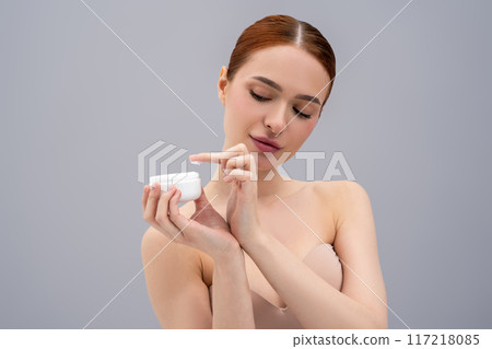 Pretty young woman trying a new face cream and looking relaxed and enjoyed 117218085