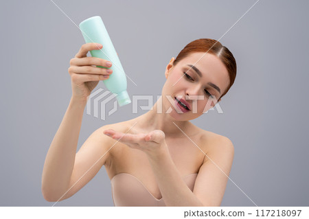 Young ginger woman using anti-dandruff shampoo while washing her hair 117218097