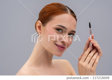 Portrait of a smiling young woman with an eyebrow brush in hands Portrait of a smiling young woman with an eyebrow brush in hands 117218099