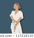 A woman in a flowing white dress stands gracefully by a blue wall 117218110