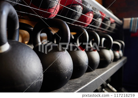 Close up background image of kettlebells in row on equipment rack in weight training gym copy space Close up background image of kettlebells in row on equipment rack in weight training gym copy space 117218259