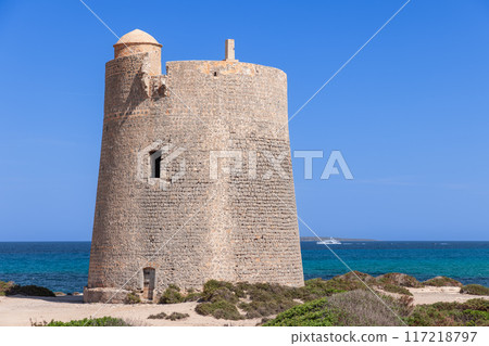 Torre de ses Portes, a medieval stone tower on Ibiza, overlooks the crystal clear Mediterranean Sea 117218797