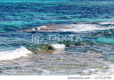 Texture of crystal-clear sea water with varying shades of blue and turquoise, transparency 117218799