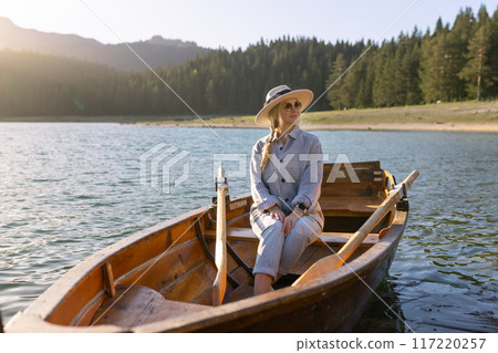 Portrait of a young woman rowing a boat on a spring day in Durmitor National Park in Montenegro Portrait of a young woman rowing a boat on a spring day in Durmitor National Park in Montenegro 117220257