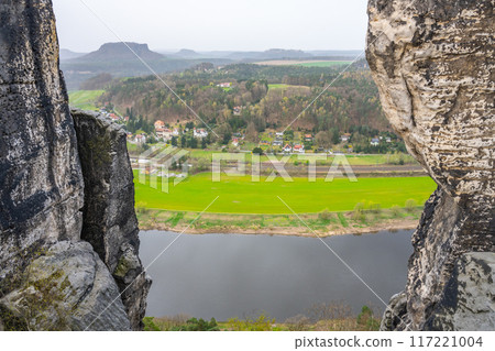 The Elbe River winds through Saxon Switzerland National Park, framed by the towering Bastei rock formations. Kurort Rathen, Germany 117221004