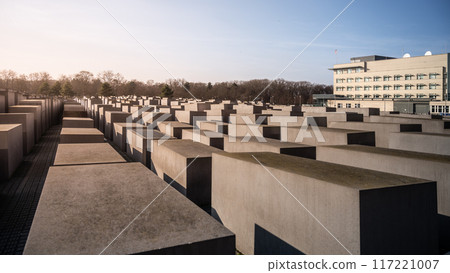 Rows of concrete slabs forming the Holocaust Memorial under clear skies in Berlin, Germany Rows of concrete slabs forming the Holocaust Memorial under clear skies in Berlin, Germany 117221007