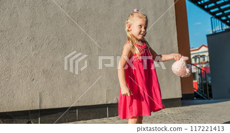 Child with hearing problem and cochlear implant dance in street, deaf kid began to hear. Hearing loss in childhood and treatment concept. Copy space and empty place for text banner. Inclusion and 117221413