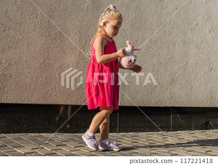 Funny baby with cochlear implant walks outdoor copy space. Hearing aid and medicine innovating technology concept. Diversity and Inclusion and people with disability concept. Funny baby with cochlear implant walks outdoor copy space. Hearing aid and medicine innovating technology concept. Diversity and Inclusion and people with disability concept. 117221418