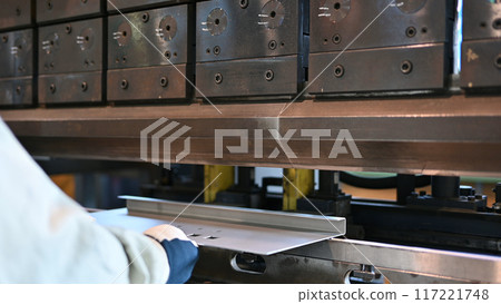 An operator bending steel materials with a bender (finish of bending) Factory Ironworks 117221748