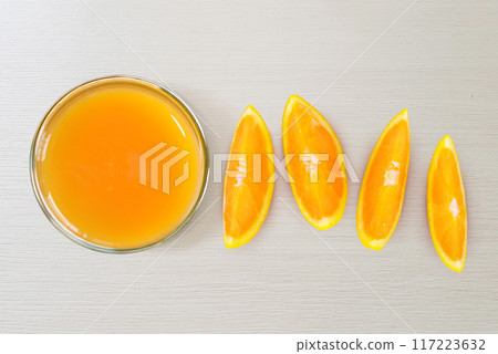 A glass of orange juice and sliced oranges top view isolated on white background A glass of orange juice and sliced oranges top view isolated on white background 117223632
