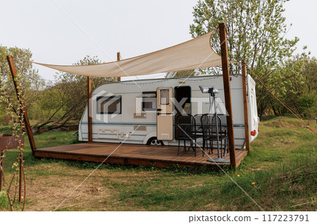 Caravan or camper trailer with Wooden Deck at Countryside Glamping Site. Outdoor Camping Caravan or camper trailer with Wooden Deck at Countryside Glamping Site. Outdoor Camping 117223791