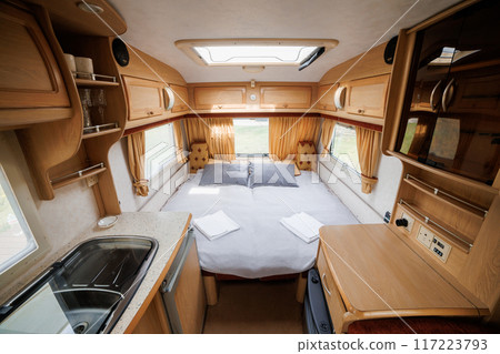 Cozy Caravan Interior with Kitchen and Sleeping Area. Ideal for Glamping, Camping, and Mobile Living 117223793