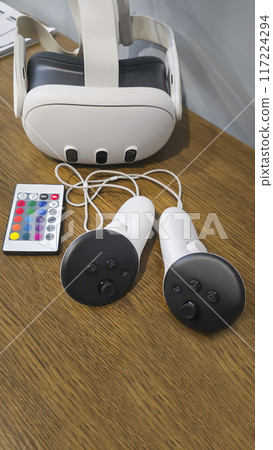 Virtual game set. VR headset. Glasses are on the table next to the control panel Virtual game set. VR headset. Glasses are on the table next to the control panel 117224294