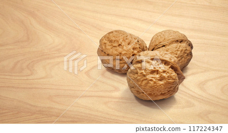 Walnuts on wooden background, front view Walnuts on wooden background, front view 117224347