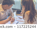 Young lady discussing with her partner showing data on tablet 117225244