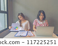 Two young freelancer women working on laptop and business paperwork 117225251