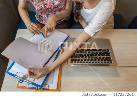Close up of woman hand pointing at business graph document 117225261