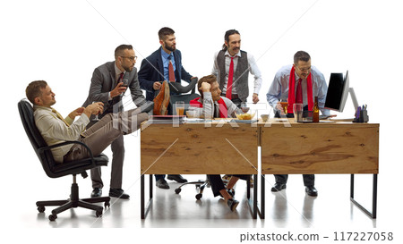 Football enthusiast intensely looking at computer screen follow development of game against white studio background. 117227058