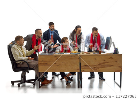 Group of men drinks beer and watching final football game intensively looking at computer screen against white studio background. 117227065