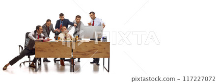 Banner. Male professionals watching football on PC during working time and drinks beer against white background. Copy space. Banner. Male professionals watching football on PC during working time and drinks beer against white background. Copy space. 117227072