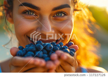Radiant Athletic Woman savoring Blueberries in Morning Glow 117227126